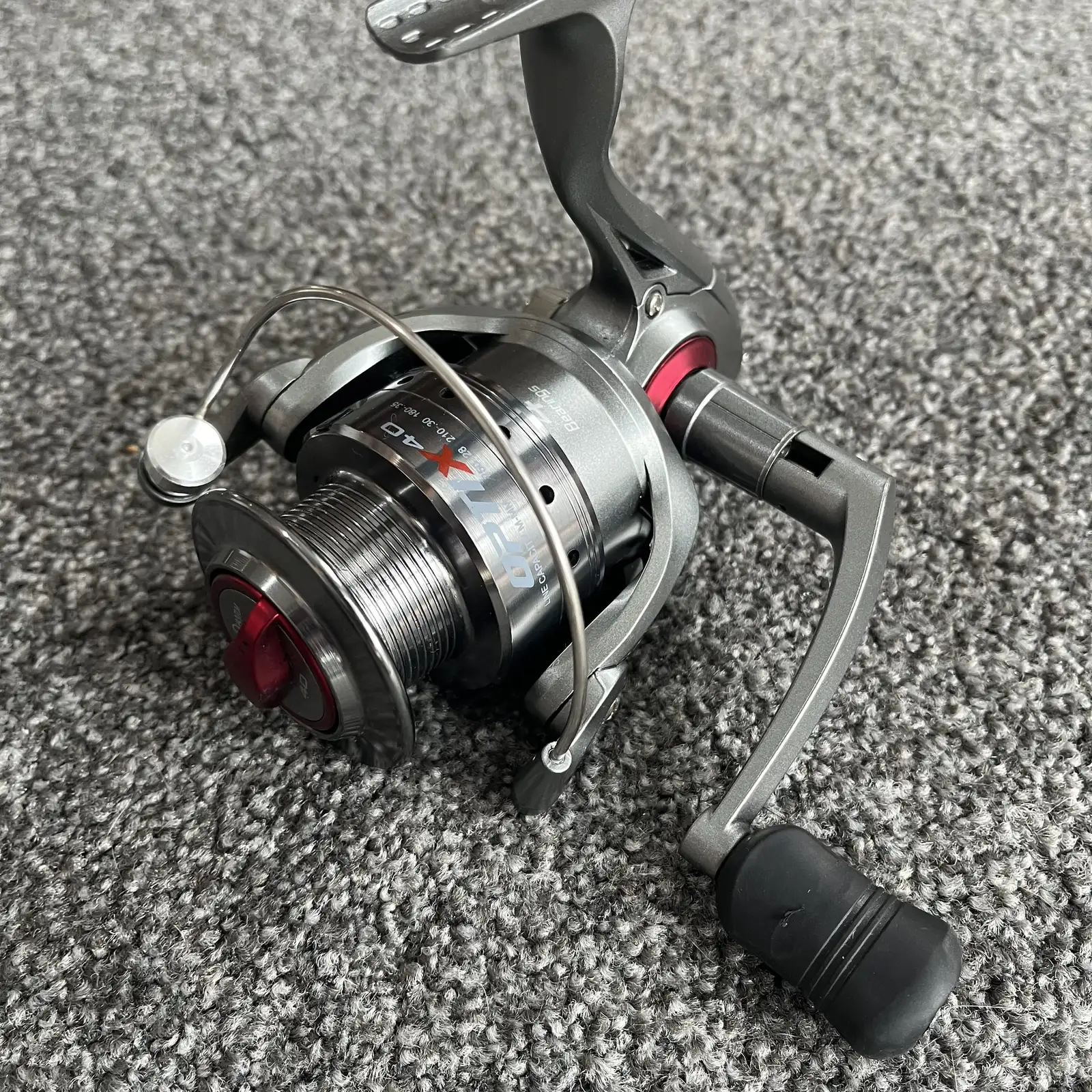Used Quantum Optix 40 spinning reel, grey and red, three-quarter view