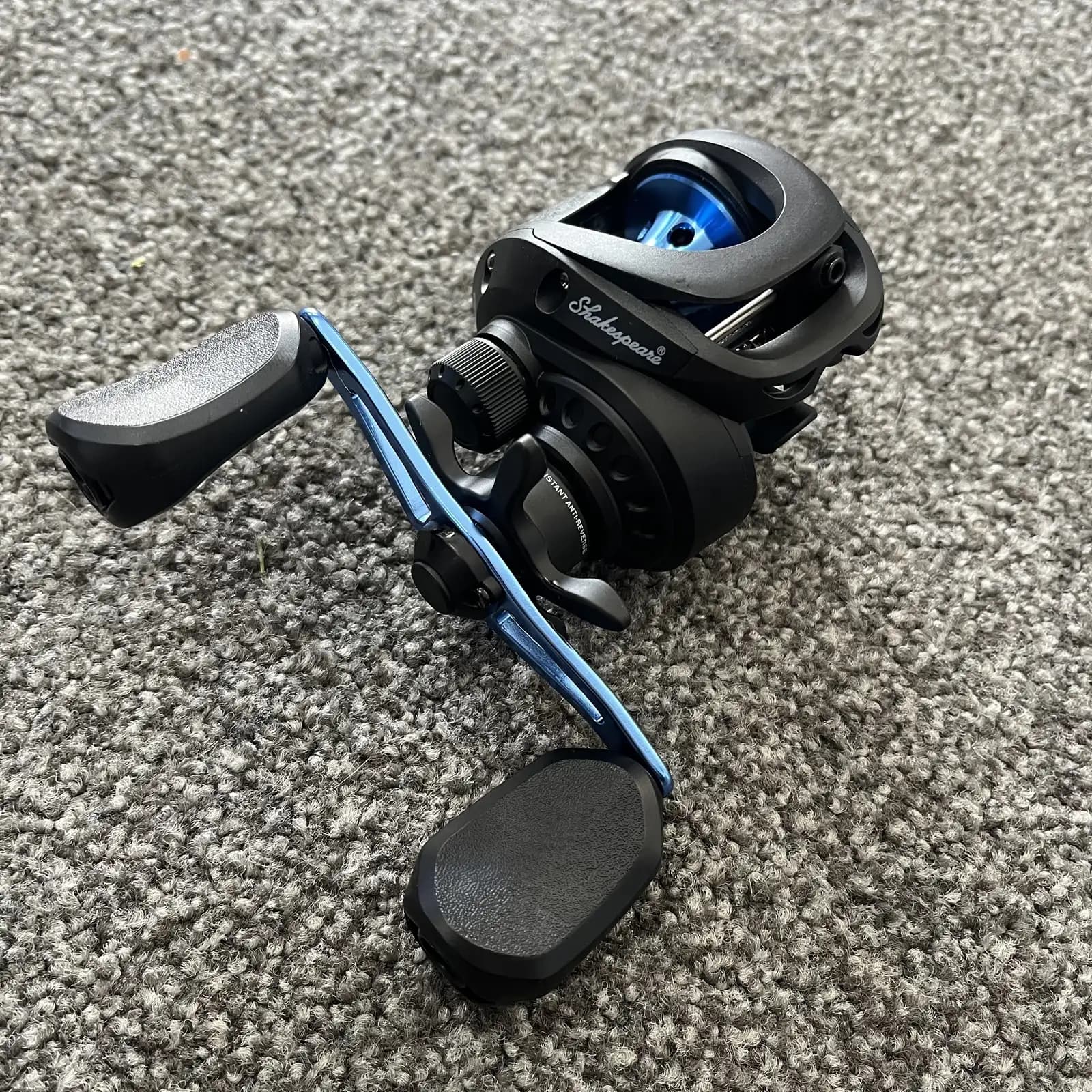Shakespeare Agility LP low-profile baitcaster with blue handle, three-quarter view